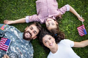 Featured image for Morale, Welfare, and Recreation programs – also called MWR programs – showing a happy military family lying on the grass