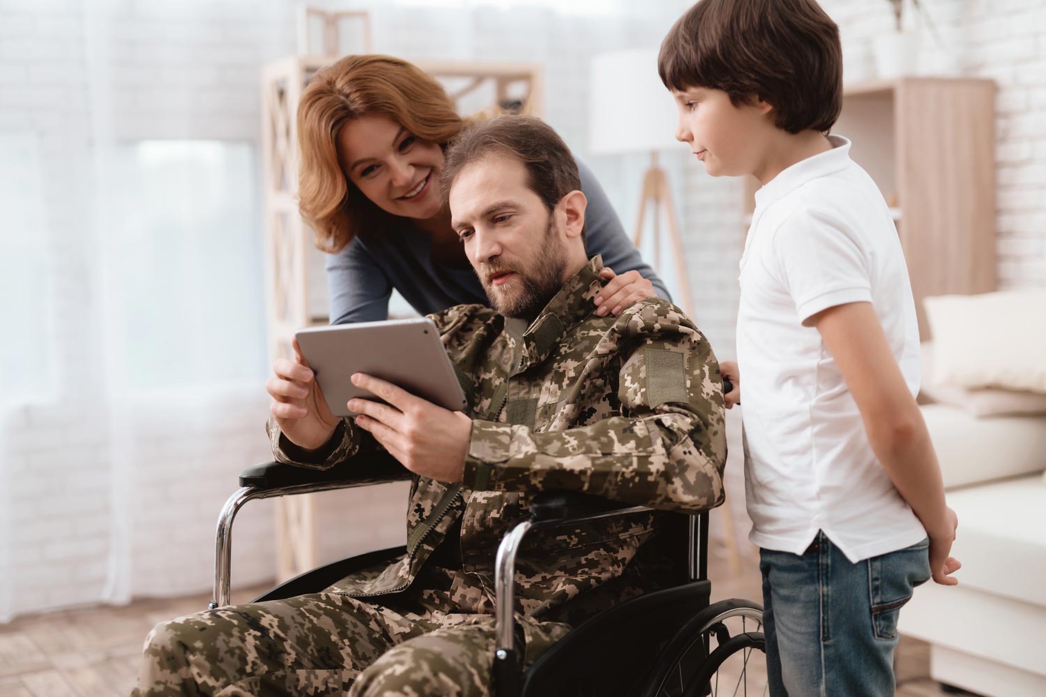 Featured image for 100% VA Disability Benefits, showing a disabled Veteran in a wheelchair with his family