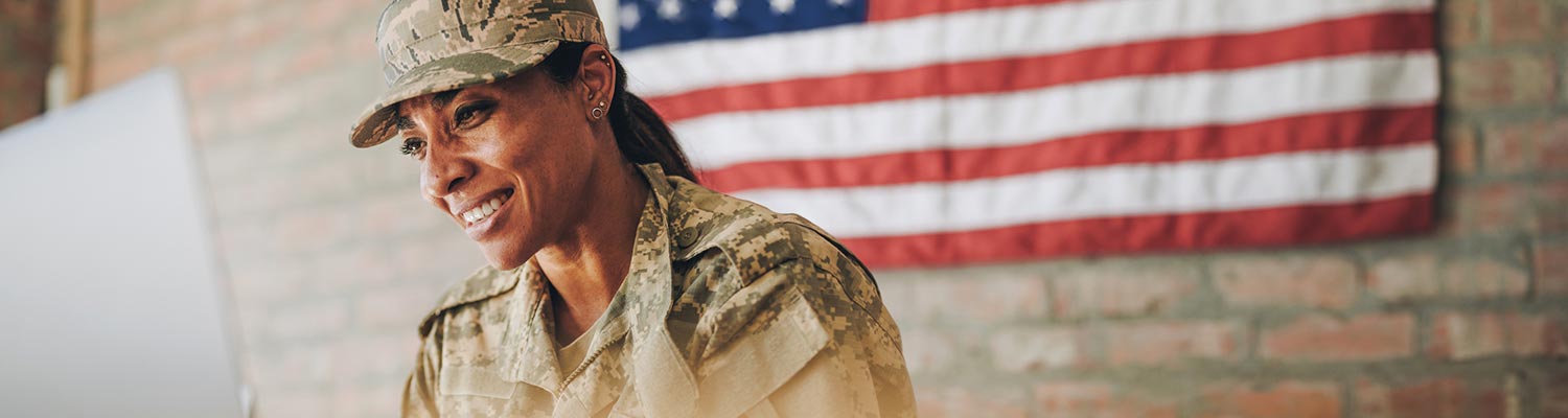 Featured image for contacting Brave Veteran, showing a female soldier on her laptop with a flag of the United States in the background