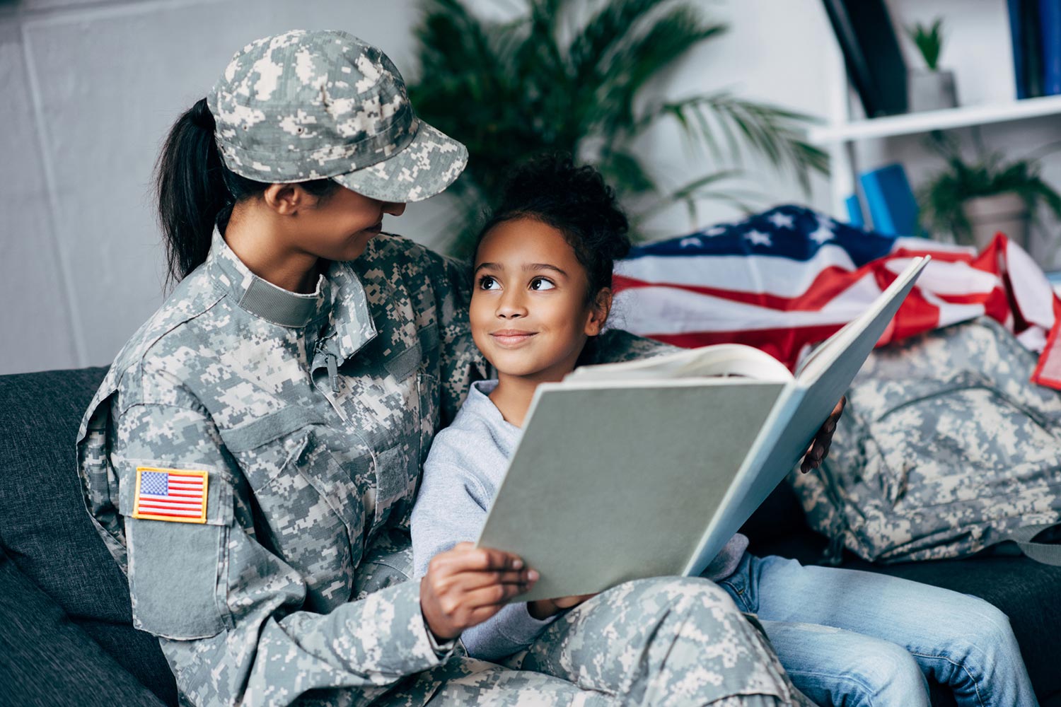 Featured image for VA Education Benefits for Dependents and Survivors, showing a female soldier with her daughter reading together in their home