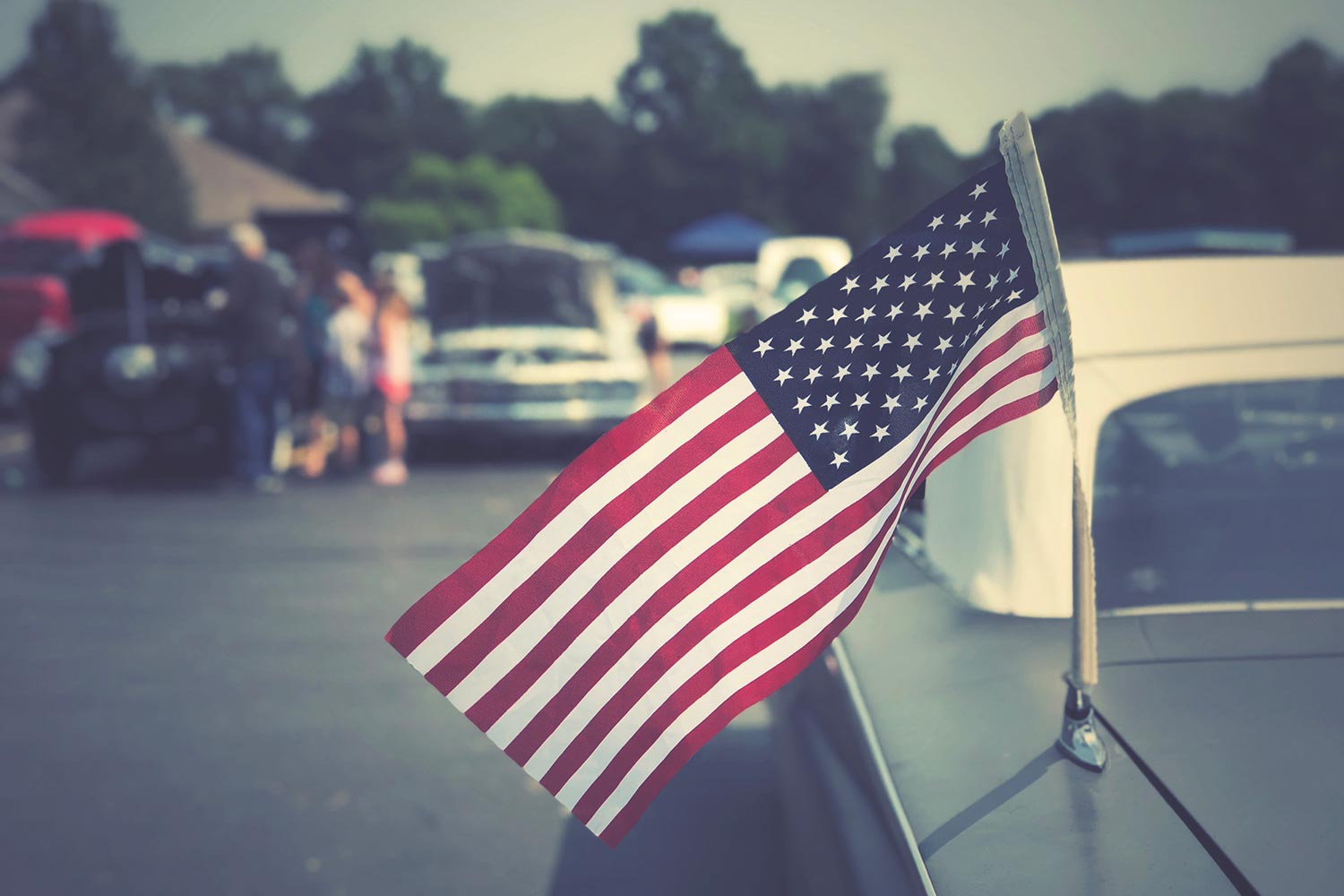 Featured image for Veteran Auto Insurance, showing a flag of the United States on a classic car