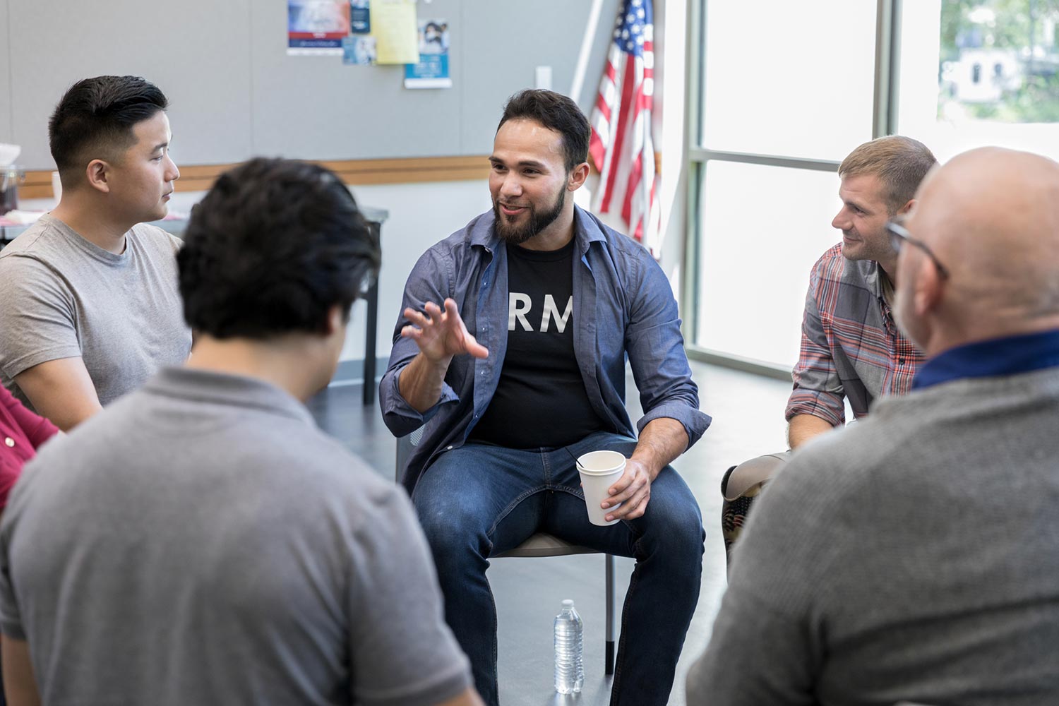 Featured image for Veteran Jobs, showing a Veteran leading a group meeting in a community center